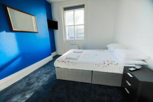 海斯廷斯Stowaway的一间卧室配有一张蓝色墙壁的床