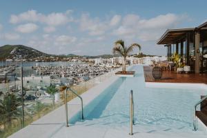 圣埃乌拉利亚Aguas de Ibiza Grand Luxe Hotel - Small Luxury Hotel of the World的享有海滩景致的游泳池