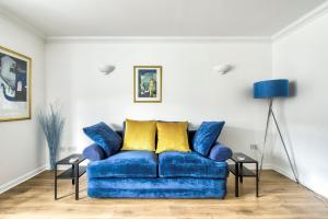 爱丁堡GuestReady - Stylish Apt w/ Parking near Edinburgh的客厅里配有带黄色枕头的蓝色沙发