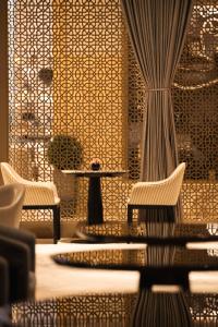 迪拜Kempinski Central Avenue Dubai的一间设有两把椅子、一张桌子和柱子的房间