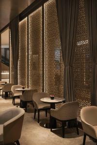 迪拜Kempinski Central Avenue Dubai的一间带桌椅和窗帘的餐厅