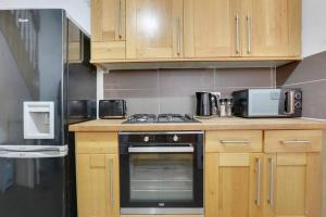赫尔Cosy home in Newland Avenue area的厨房配有木制橱柜和炉灶烤箱。