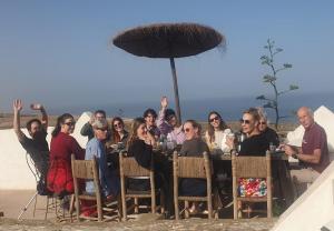 DouaïraRiad Sahara Sunset Beach Agadir的一群人坐在海滩上的桌子上