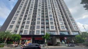 胡志明市Vinh Hoi Apartments - Luxury Apartment Furnished Suites的一座高大的建筑,前面有一辆汽车