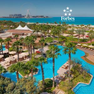 迪拜迪拜丽思卡尔顿酒店的享有棕榈树和游泳池度假村的空中景致