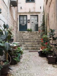 杜布罗夫尼克Ella la Bella II Dubrovnik Old town的楼前有楼梯和盆栽的小巷