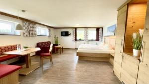 里登施瓦岑巴赫康体&Spa酒店的酒店客房带一张床、一张桌子和椅子