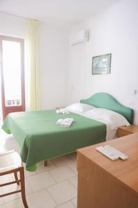 伊斯基亚赛索塔酒店的酒店客房,配有两张带绿床单的床