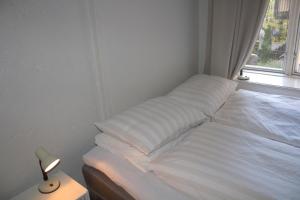 奥斯陆北欧旅舍 - 德施曼门10号的窗户客房内的一张白色床
