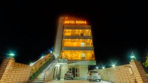 德拉敦Hotel Rudra的夜间标有标志的酒店大楼