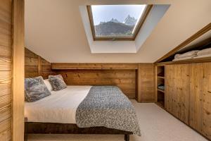 夏蒙尼-勃朗峰Chalet les Sauberands的一间卧室配有一张床和天窗