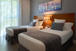 马德里托莱多门酒店的酒店客房设有两张床和窗户。