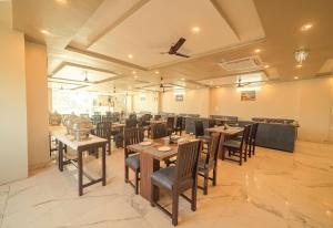 德拉敦Hotel Rudra的用餐室配有木桌和椅子