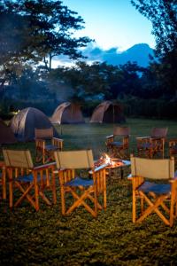 TuvailaCharming Eco-Campsite near Kilimanjaro International Airport的一组椅子和一张桌子,火炉