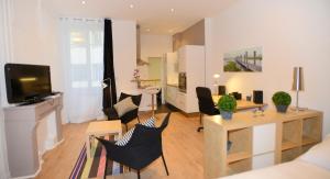 里昂共和公寓的客厅配有桌椅和电视。