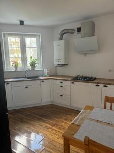 科沙林Apartament Lux的厨房配有白色橱柜、水槽和桌子