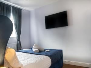 贝克斯利黑思Royal Luxe 6 Bed House in London的一间卧室配有一张床和一台平面电视
