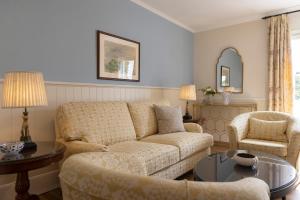 米克诺斯城科嫩尼公寓的客厅配有沙发和两把椅子
