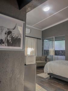 内尔斯普雷特View Inn Exclusive Lodge的卧室配有一张床,并画着一幅牛的照片