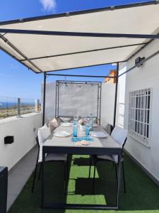 圣克鲁斯-德特内里费Ático Micaela. Terraza y vistas的阳台配有桌椅和白色天篷