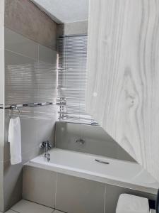 内尔斯普雷特View Inn Exclusive Lodge的白色的浴室设有浴缸和窗户。