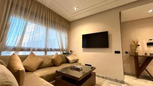 卡萨布兰卡Les Joyeux Luxury Suites & Appart的带沙发和大窗户的客厅