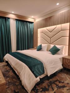 乌姆莱季همم للوحدات السكنيه المخدومة- الدقم的一间卧室配有一张带绿色窗帘的大床