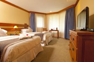 查卡布科港Loberias Del Sur的酒店客房设有两张床和一台平面电视。