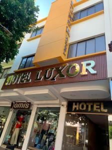 库库塔Hotel Luxor Cúcuta的大楼前的酒店标志
