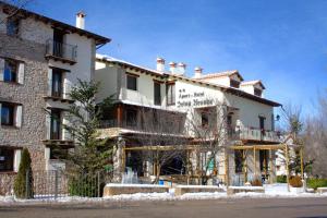 La Virgen de la VegaApart-Hotel Selva Nevada的一座白色的大建筑,地面上积雪