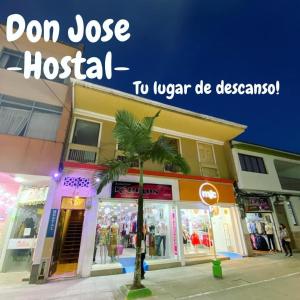 圣罗莎德卡瓦尔Hostal Don Jose的一座建筑前有棕榈树的商店