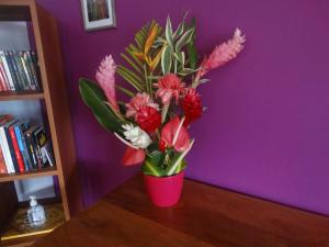 莱特鲁瓦西莱La Villa Des Tropiques - Turquoise的粉红色的花瓶,花朵放在桌子上
