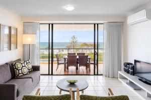 亚历山德拉岬角Oaks Sunshine Coast Seaforth Resort的客厅配有沙发和桌子