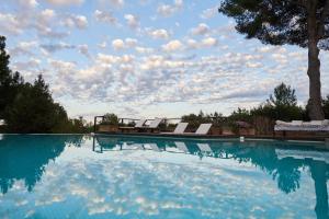 伊维萨镇Lilita House的一个带椅子的游泳池,天空阴云