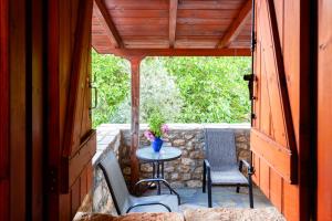MiléaMilea Traditional House-Private Garden Retreat的石墙上配有桌椅的庭院
