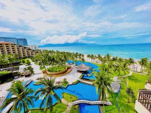 岘港岘港皇冠假日酒店的享有棕榈树和海洋度假村的空中景致