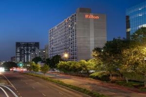 阿林顿Hilton Arlington National Landing的一座高大的建筑,晚上有黑尔顿标志