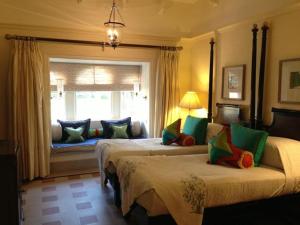 乌代浦乌代浦乌代维拉斯欧贝罗伊饭店的一间卧室设有两张床和窗户。