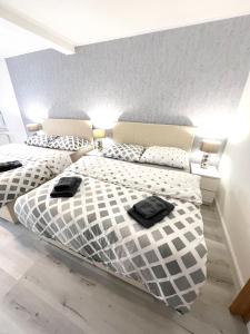 特普利采GrandLux Villa & Spa的一间卧室配有两张床和黑色毛巾。