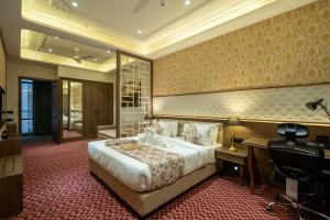 艾哈迈达巴德Hotel Mivaante的配有一张床和一张书桌的酒店客房