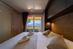 奥瑞比克Mobile Homes Camp Perna - Adriatic Kampovi的一间卧室配有一张床,上面有两条毛巾