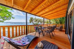 奥瑞比克Mobile Homes Camp Perna - Adriatic Kampovi的木制甲板上配有桌椅