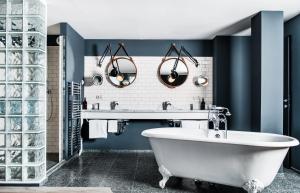 维也纳维也纳市中心费迪南德大酒店的浴室设有白色浴缸和蓝色的墙壁。