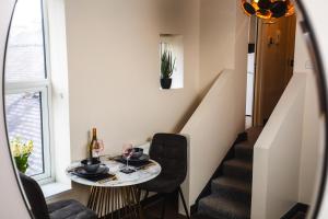 滨海索尔特本Black Pearl Stays - Saltburn Apartments的一间带桌椅和楼梯的用餐室