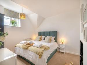 克罗默Stone Cottage的一间卧室配有一张带绿色床头板的床