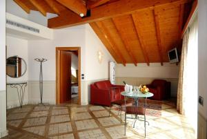 奥尔塔圣朱利奥拉布索拉酒店的客厅配有红色的沙发和桌子