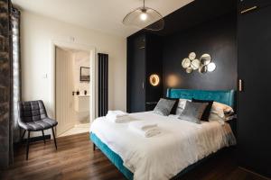 滨海索尔特本Black Pearl Stays - Saltburn Apartments的一间卧室配有蓝色的床和椅子