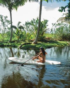 喀巴里特Kibayo Lagoon Villa的坐在水中桨板上的女人