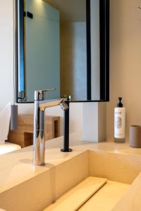 卡塔科隆PHEIA, Vriniotis Resorts的浴室水槽和镜子前的水龙头