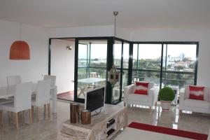卡斯卡伊斯Apartment Outeiro da Vela的客厅配有白色的椅子和一张桌子及电视
